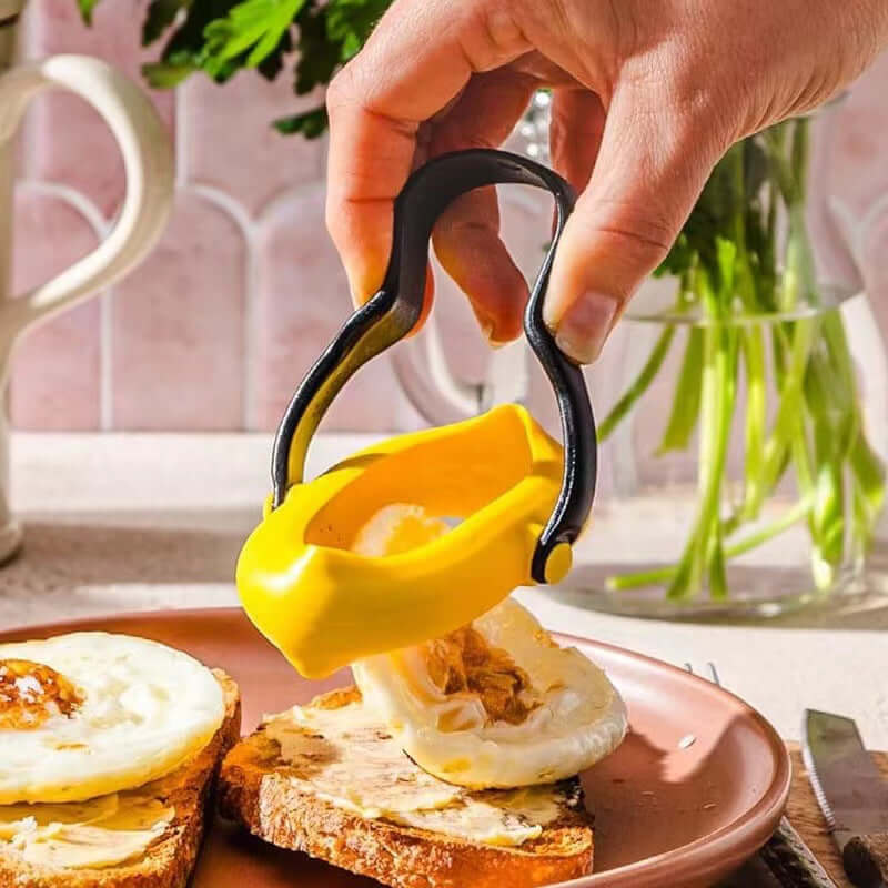 anti-leakage fried egg mold being used to lift a fried egg from a plate with toast.