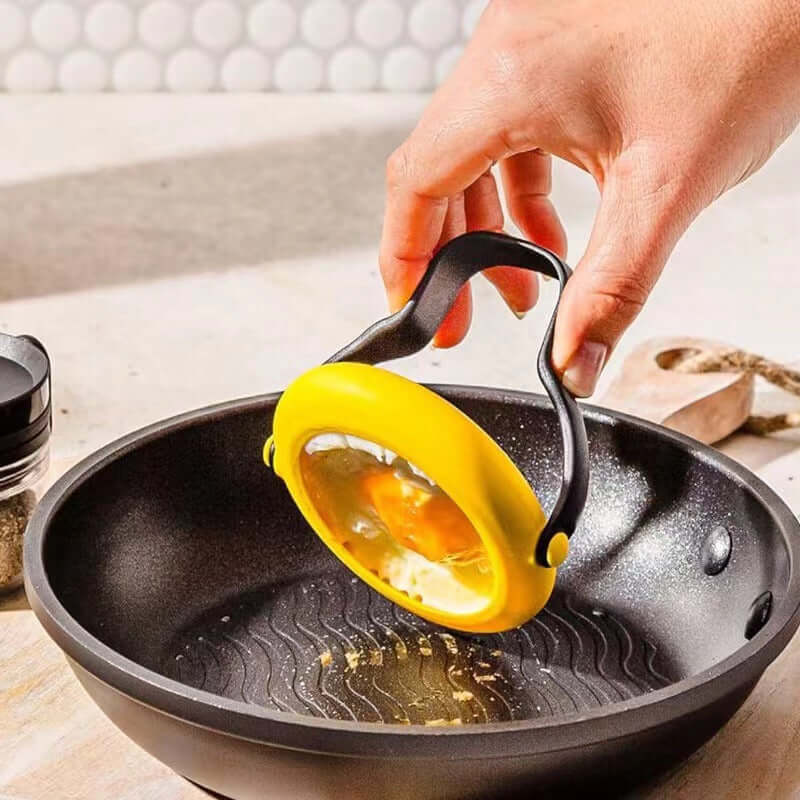 Person using an anti-leakage fried egg mold to cook an egg in a pan.