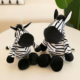 Safari adventure plush toys featuring two adorable zebra plushies with black and white stripes on a table.